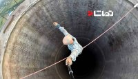 راه رفتن روی طناب بر فراز دودکشی پر ارتفاع
